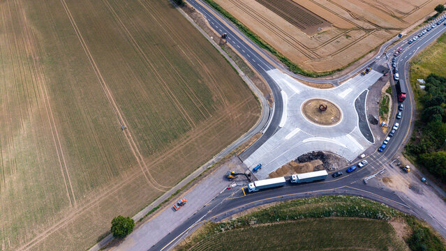Luftaufnahme von einem neu gebauten Kreisverkehr zwischen Feldern