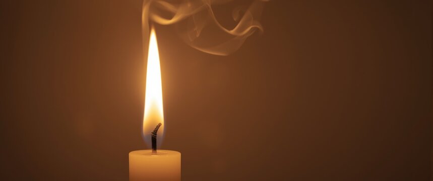 Candle flame and smoke against a soft background