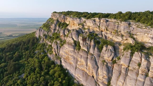 Cape Kaliakra peninsula spring aerial panoramic view Black Sea coast Bulgaria asphalt road winding drone shot morning sun green rocky cliff ocean horizon travel destination web header