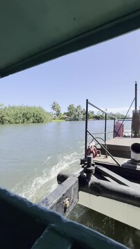 21 October 2024, USA, Hawaii, The Garden Isle, Kauaʻi, Kapaa, Wailua River - fern grotto tourist boat tour cruise boat rear-engine system overlooking riverbank