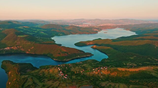 Kardzhali reservoir panoramic aerial view Rhodope mountains Bulgaria curved lake drone shot warm sunset light countryside village travel destination background header