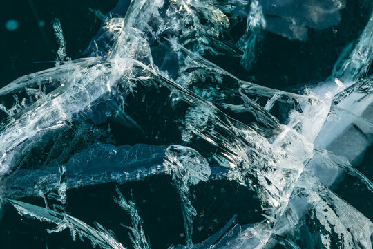View of intricate patterns of deep cracks and fractures in the thick transparent ice of Lake Baikal in Khuzhir, Irkutsk Oblast, Russia.