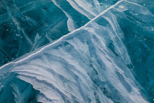 View of the intricate patterns and deep blue cracks in the frozen surface of Lake Baikal, Khuzhir, Irkutsk Oblast, Russia.