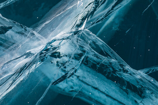 View of intricate patterns of deep cracks and fractures in the thick transparent blue ice of Lake Baikal in Khuzhir, Irkutsk Oblast, Russia.