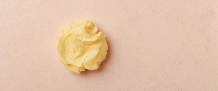 Creamy butter on a pink surface
