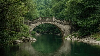 Fototapeta premium Stone bridge arching over a tranquil river surrounded by trees