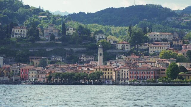 View from a pleasure ferry across the lake to the mountains and village, concept of beautiful nature and travel. High quality 4k footage