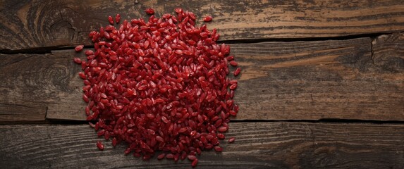 Fototapeta premium Red rice grains arranged on rustic wooden surface