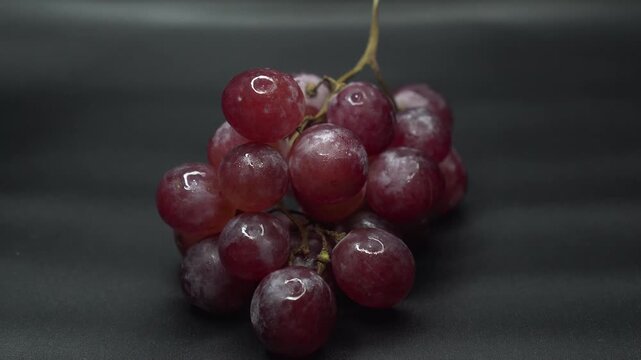 fresh red grapes isolated on a dark studio background.