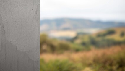 Fototapeta premium Concrete wall with blurred green landscape in the background