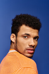Fototapeta premium A charming african american man showcases his captivating expression while looking over his shoulder.
