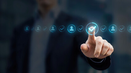 Fototapeta premium Business professional interacting with a glowing digital interface showing human resource management checkmark icons online