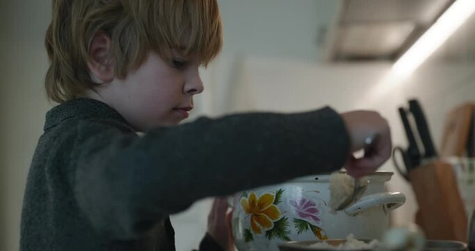 Kid Boy Prepares Rice for Meal in Kitchen. 4K 10-bit