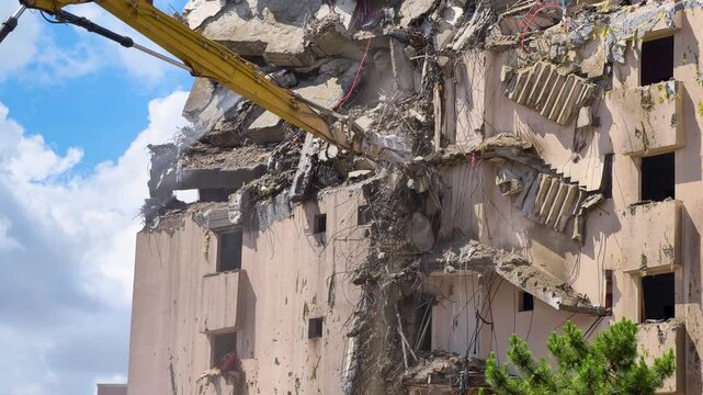 Demolition of a building in an urban area using heavy machinery and equipment during daytime