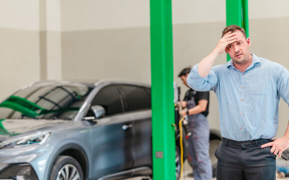 Frustrated customer talking on phone about expensive EV car repair at auto service center