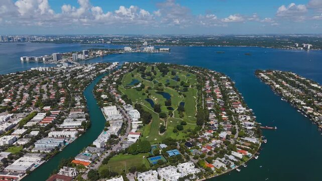 Aerial view of golf course and waterfront residential neighborhood with canals in Miami Beach