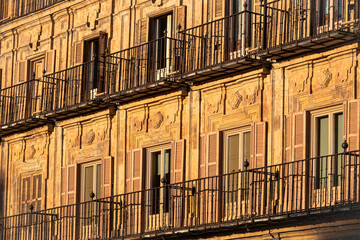 Sunlit balconies and historic facade of Plaza Mayor in Salamanca, Spain