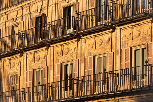 Sunlit balconies and historic facade of Plaza Mayor in Salamanca, Spain