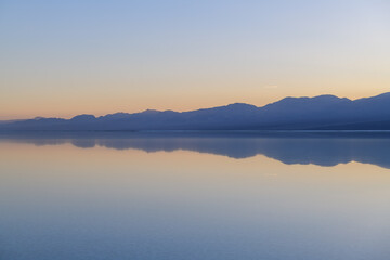 Fototapeta premium Sierra nevada california lake mountain reflection sunset sky water serene landscape with calm horizon and blue twilight glow