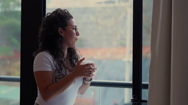 Young woman enjoying a hot coffee by the window