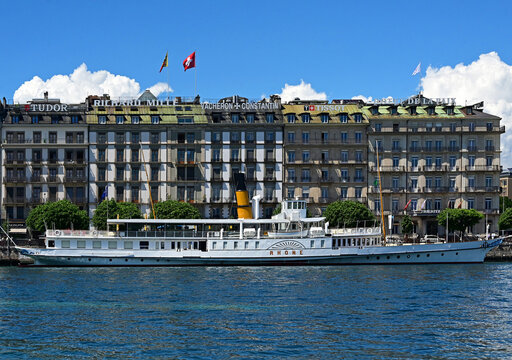Geneva, Switzerland, Europe - 05.2026 : CGN - Lake Geneva General Navigation Company, Rh&ocirc;ne - historic Belle Epoque paddle steamboat moored in Mont-Blanc port, facades along Quai du Mont-Blanc