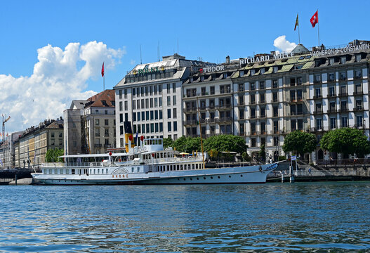 Geneva, Switzerland, Europe - 05.08.2026 : CGN, historic cruise steamboat RHONE moored in Mont-Blanc port, facades along Quai du Mont-Bland in background