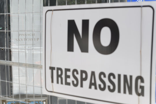 through barrier fence view of banner at Sky Tower by Pinnacle International, 1 Yonge St, with no trespassing sign, Toronto, construction, site