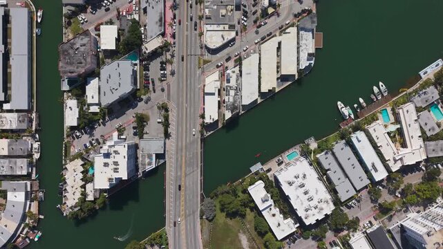 Title: Top down aerial view of a bridge crossing a canal in a residential neighborhood