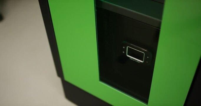 Close up view of a small digital screen display integrated into a green industrial storage cabinet machine