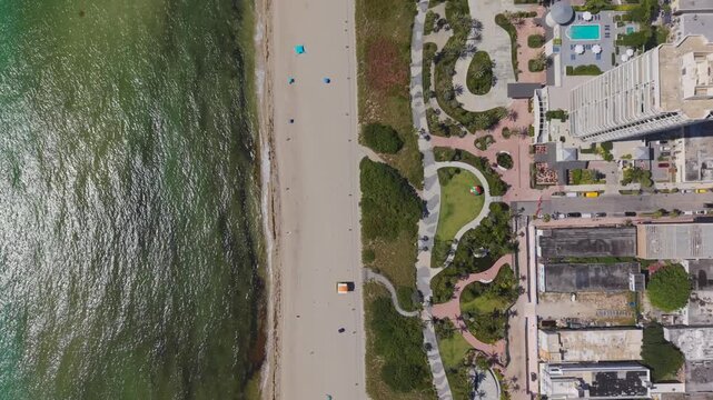 Top down aerial view of  Miami Beach boardwalk park and sandy shoreline