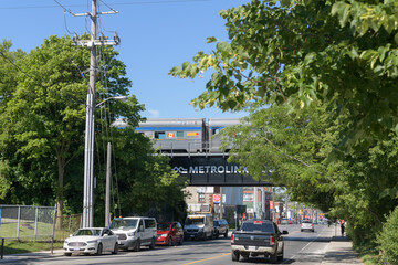 Obraz premium looking west on Rogers Rd to Go Barrie line with VIA Rail passenger cars runny by, Toronto