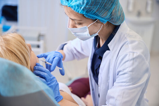 Female medical professional administering cosmetic injection indoors
