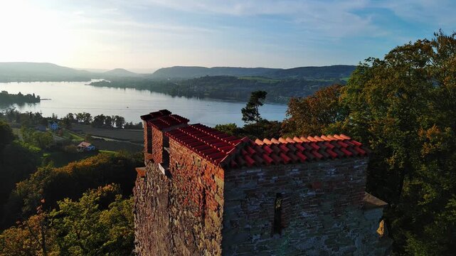 Drone View of Ancient Castle Ruin Overlooking a Serene Lake Valley