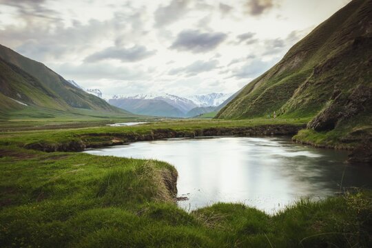 Scenic Truso Valley in Georgia with winding river, green meadows, and Caucasus mountains in background, popular hiking and trekking destination near Kazbegi, eco tourism and nature landscape