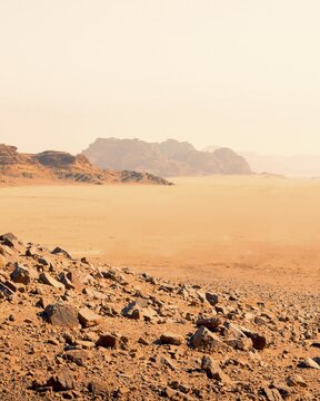 Expansive barren desert of Wadi Rum in Jordan with red sand, rocky terrain, and distant mountains. UNESCO World Heritage site, famous filming location for science fiction movies such as The Martian and Dune