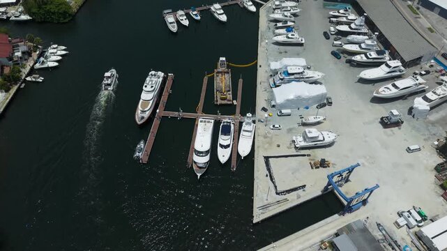 Top down aerial view of boat cruising in river near boat marina and dry dock