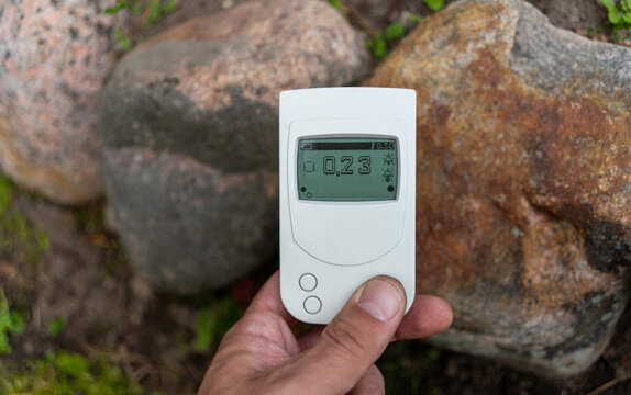 Radiation dosimeter in your hands.Checking the radiation background on the street.Dangerous radiation from granite stones.