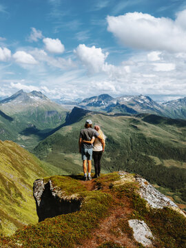 Couple hikers in love hugging on mountain cliff edge travel together family in Norway on romantic summer vacations, boyfriend and girlfriend enjoying nature view active healthy lifestyle tour outdoors