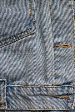 Detail view of denim jacket buttonhole and hem