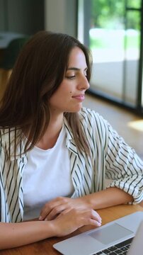 Satisfied businesswoman finishing her work on a laptop, stretching her body, and relaxing in her chair while working from home, feeling happy with the completed project