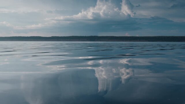 Glassy surface of the river with reflection of the cumulonimbus clouds