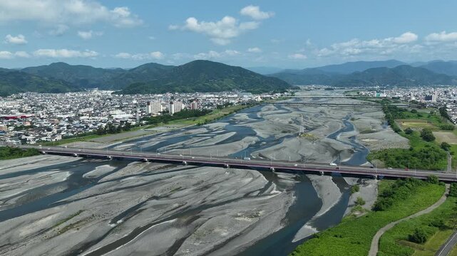Aerial drone footage of Abekawa River braided channels and Shizuoka cityscape