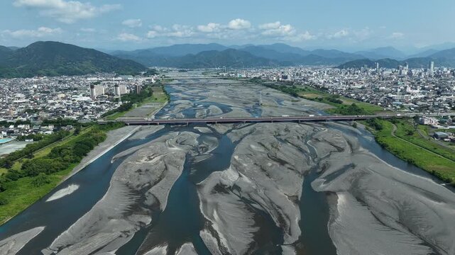 Aerial drone footage of Abekawa River braided channels and Shizuoka cityscape