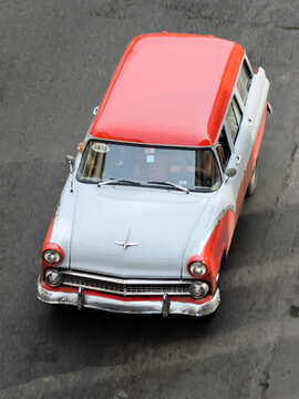 Havana, Cuba - 5th June 2015 - Classic red and white vintage Ford Country Sedan driving on an urban street, viewed from above