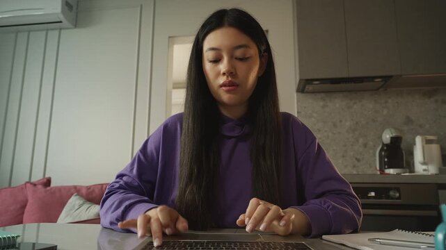 POV of a young Korean journalist typing on a laptop while working from home