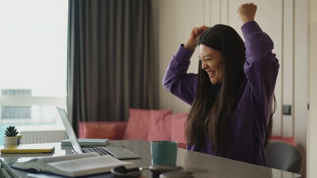 Young Korean woman receiving a good news email, celebrating a lottery win