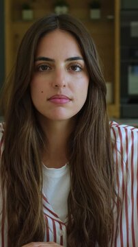 Beautiful young woman with long brown hair in deep thought, her gaze shifting as she reflects. A pensive and serene portrait capturing a moment of introspection and contemplation indoors