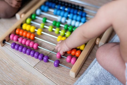 Colorful abacus with child's hand.