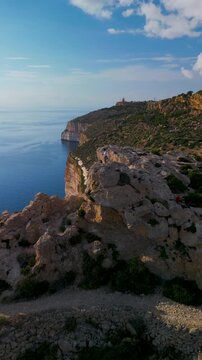 Man silhouette standing on mountain cliff rock horizontal sea aerial drone view.
