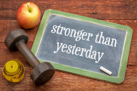 Stronger Than Yesterday &ndash; motivational text in chalk on vintage slate blackboard, fitness progress, discipline, health, and self-improvement.